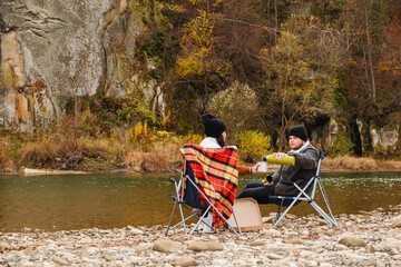 happy couple having picnic at river beach