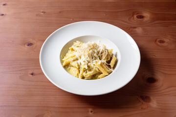 penne, alla, nerano, zucchine fritte, formaggio, grattugiato, dop, provolone, del, monaco, pepe, nero, basilico, pasta, italia, legno, tavolo, grezzo, venature, marrone, piatto, bianco, inclinato, pro