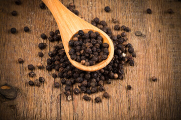 black pepper on wooden spoon