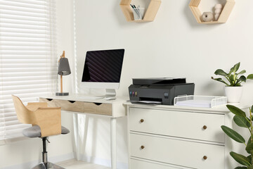 Stylish workplace with modern computer, printer and lamp