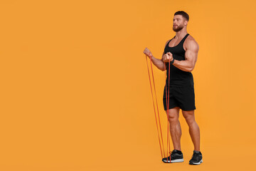 Young man exercising with elastic resistance band on orange background. Space for text
