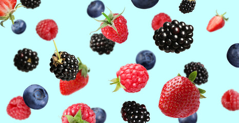 Many different fresh berries falling on light blue background