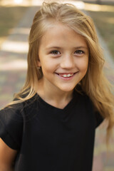 a large portrait of a blonde girl with big eyes and long hair in a black jacket