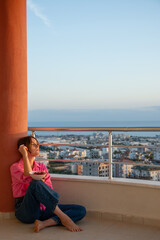 Beautiful girl on the balcony overlooking the sea