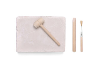 Educational toy for motor skills development. Excavation kit (plaster, digging tools and brush) isolated on white, top view