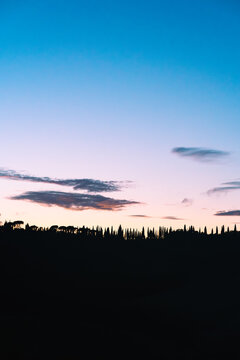 Tuscany Sunset Landscape with Backlit Tree Silhouettes on Hill - Scenic Italian Countryside