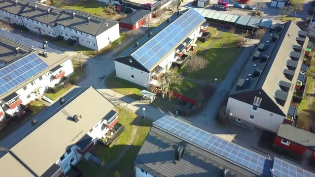 Renewable electricity development. Solar photovoltaic panels mounted on roof of swedish condo building in Linkoping residential area
