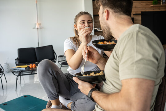 A young couple enjoys a healthy lunch together, after workout and exercise, savoring the flavors of their nutritious meal.	