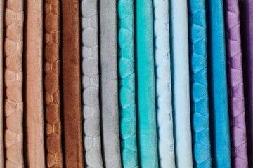 Colorful samples of upholstery fabrics close-up. Leather and suede for furniture renovation