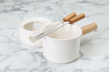 Fondue set on white marble table, closeup