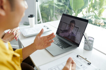 Fototapeta premium Team of developers and client having online meeting, discussing project details