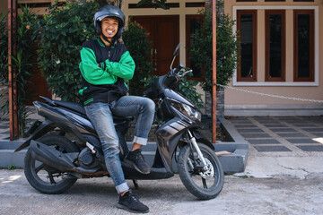 Portrait of smiling Asian commercial motorcyle online driver standing in folded arms confidently © Queenmoonlite Studio