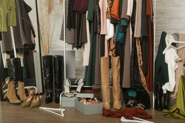 Untidy cluttered woman wardrobe with stylish clothes and accessories. Messy clothes thrown on a...