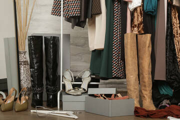 Untidy cluttered woman wardrobe with stylish clothes and accessories. Messy clothes thrown on a...