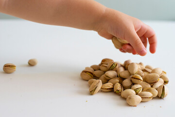 baby holding a handful of nuts