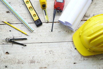 Set of professional construction tools and safety helmet on a work table. Top view. Tools. Various tools on a wooden table. engineering drawing Tools to work beyond architectural blueprints