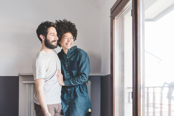 Young multiethnic couple hugging smiling indoor