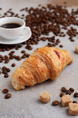 Espresso and croissant with coffee beans