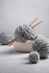 Fototapeta na wymiar Gray balls of thread with wooden knitting needles