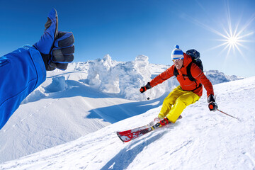 Skier is having fun during beautiful winter scenery in high mountains with thumbs up against sunset. - 652373748