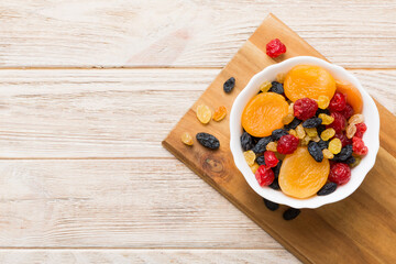 Bowl with different dried fruits on table background, top view. Healthy lifestyle with copy space