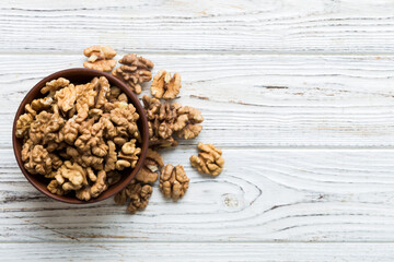 Fresh healthy walnuts in bowl on colored table background. Top view Healthy eating bertholletia concept. Super foods