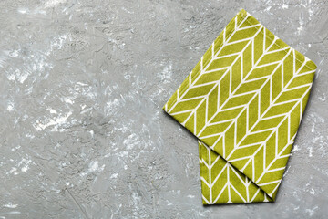 top view with green kitchen napkin isolated on table background. Folded cloth for mockup with copy...