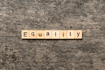 Equality word written on wood block. Equality text on cement table for your desing, concept