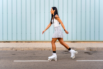 Obraz premium Portrait of a young girl roller skating on the street