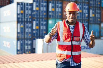 factory worker or engineer smiling and thumbs up pose in containers warehouse storage © offsuperphoto