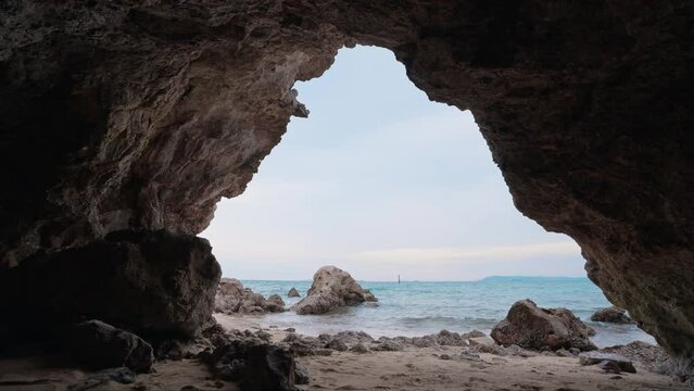 Beautiful mysterious cave entrance in bright light and sea view. Amazing caves and rock. Entrance to the cave. Travel concept