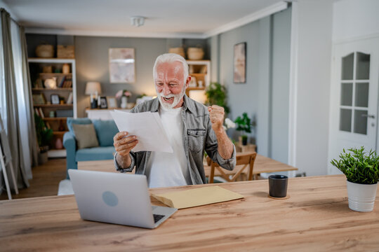 senior caucasian man open mail letter or document envelope at home