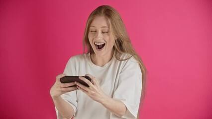 A pretty ginger girl in bright emotions expresses joy, pleasure and delight from winning the game. Efforts leads to positive results, long-awaited victory and triumph. 