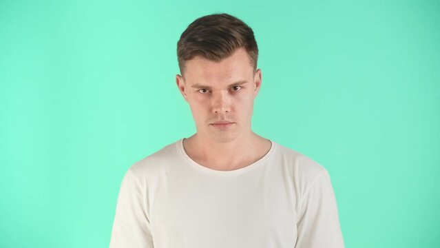 A young man with a searching look in emotions of skepticism and distrust of his interlocutor, friend, beloved or colleague. Fear of being framed, deceived or betrayed. Lack of confidence in the facts