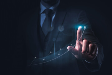 A businessman pointing at a graph and a chart, showing a corporate growth strategy or a notion for a rising company.