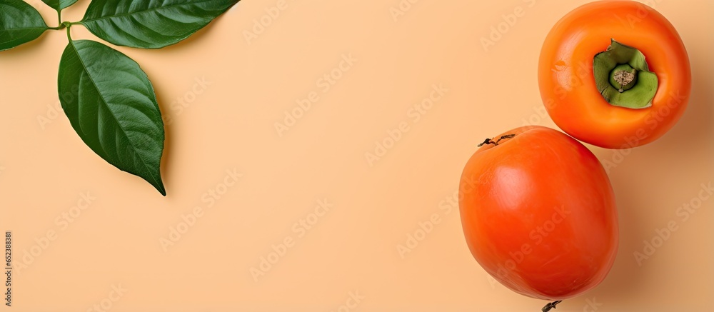 Aufkleber Whole and sliced Persimmon isolated on a isolated pastel background Copy space with green leaf
