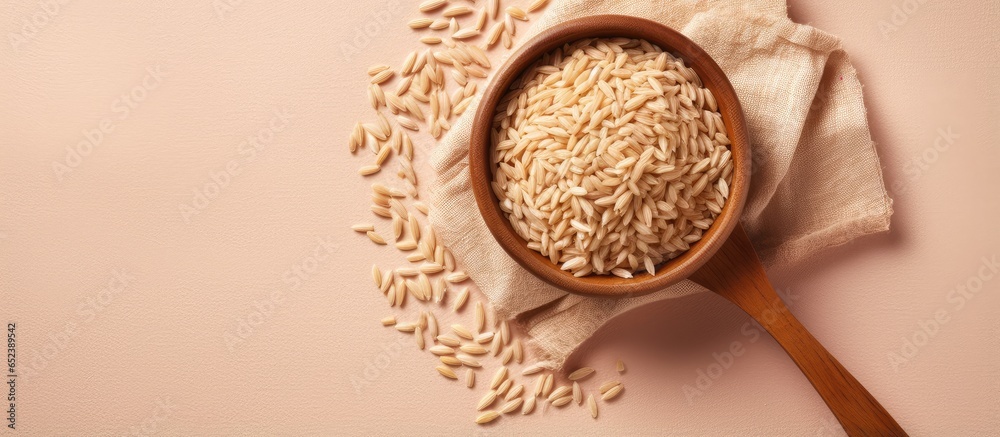 Aufkleber brown rice in wooden bowl on a isolated pastel background copy space front view naturally nutritious