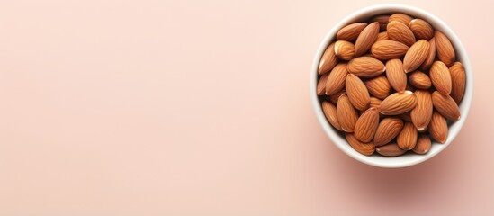 Almonds in a white bowl on a isolated pastel background Copy space with copy space have benefits for neutralizing free radicals preventing Alzheimers and repairing the body