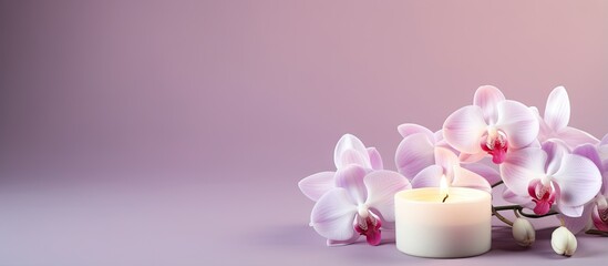 Obraz na płótnie Canvas Orchid flowers adorn a lit candle in isolation against a isolated pastel background Copy space