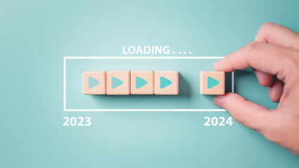 2024 New Year countdown loading. Loading bar on wooden blocks 2023 to 2024 on blue background. The beginning of the starting goal and action plan concept. - obrazy, fototapety, plakaty