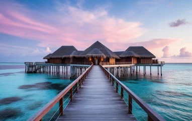 Fotobehang Wooden pier at the beach with hotel resorts at pink sunset sky. © hugo
