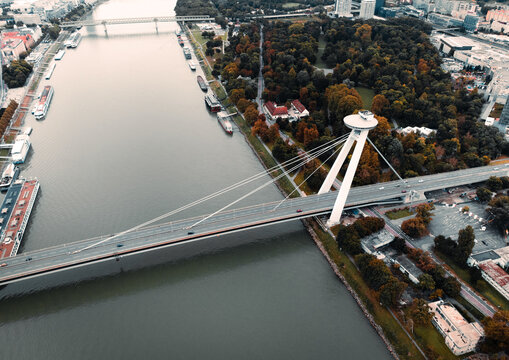 Aerial view of Ufo tower and Most SNP bridge in autumn time on sunset - taken by drone. Wide angle image of famous Ufo tower and Danube river in Bratislava - Slovakia.
