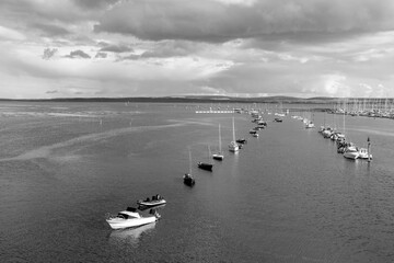 Looking out over the harbour with boats in black and white