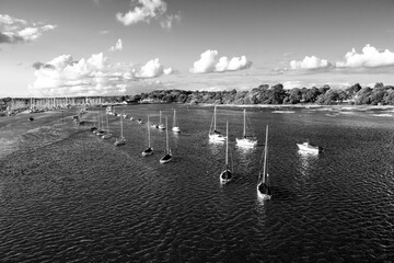 Looking out over the harbour with boats in black and white