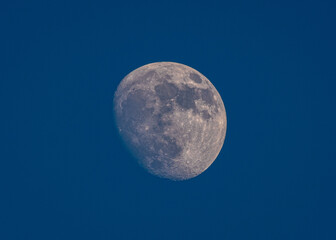 Detailed close up zoom photo of the half moon with blue background.