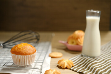 homemade muffins in white paper muffin cups and a glass of milk on the table.