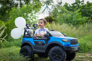 isolated cute toddler with innocent facial expression at toy car at outdoor from different angle