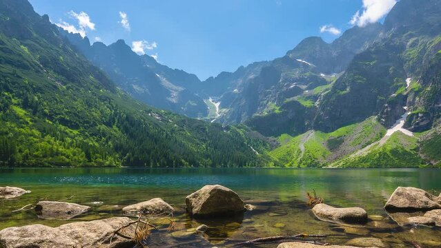 Famous mountains lake morskie oko or sea eye lake in summer day. Beautiful sky sunlight above Tatras lake landscape. UNESCO's World Network of Reserves. Tatra national park, Poland.