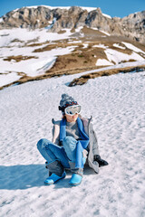 Fototapeta na wymiar Boy on snowy hill in ski sunglasses
