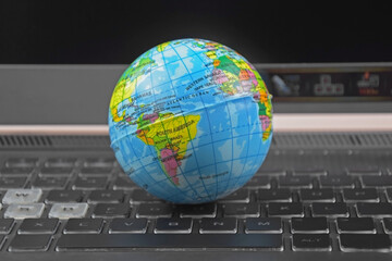 Laptop keyboard with world globe on top.